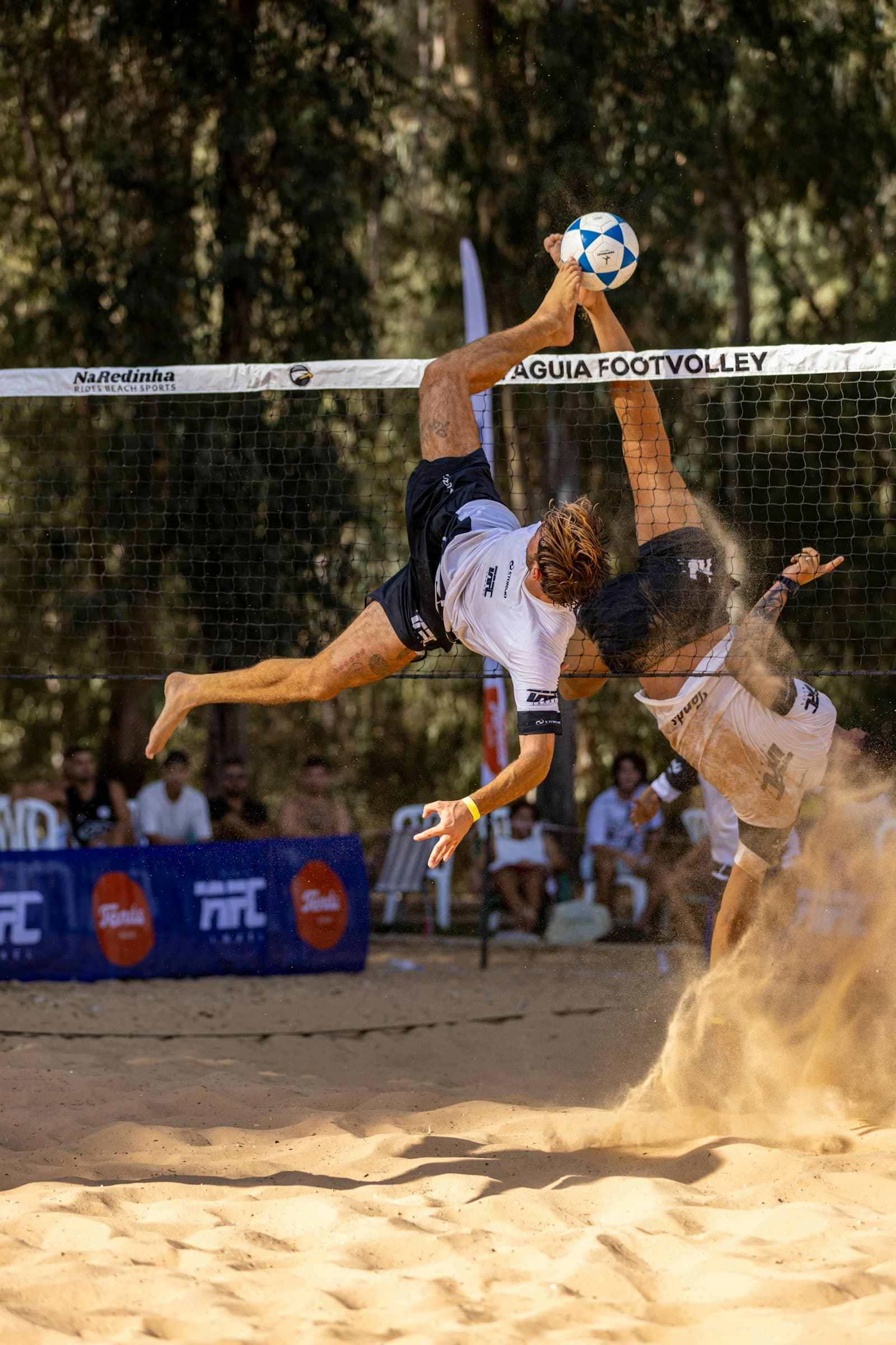 Footvolley player doing a bicycle kick over the net
