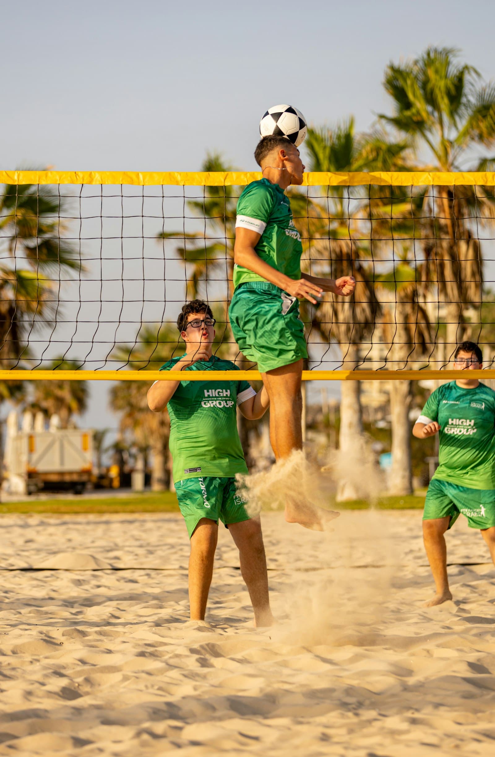 Footvolley player heading the ball at the net