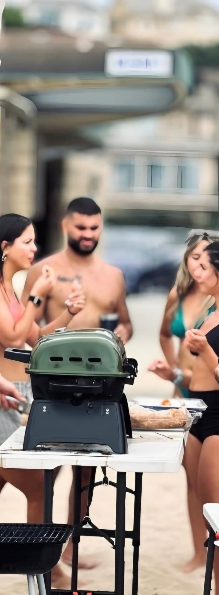 BPC players hanging out around a grill on the beach after class
