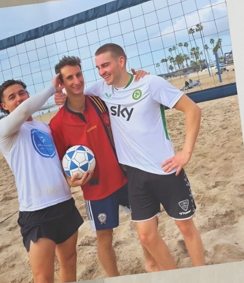Three BPC players with a ball on the beach